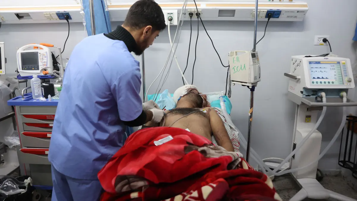 A wounded Palestinian receives medical attention at the al-Shifa hospital in Gaza City, after patients were transported from the Kamal Adwan Hospital, on December 28, 2024, amid the ongoing war between Israel and the Hamas militant group. Gaza health officials said on December 28, that Israeli forces detained the director of a hospital in the north, which the World Health Organization said was put out of service by an Israeli raid. On December 27, the Israeli military said it had launched an operation in the area of Kamal Adwan Hospital, alleging the facility was a "key stronghold for terrorist organisations". (Photo by Omar AL-QATTAA / AFP)
