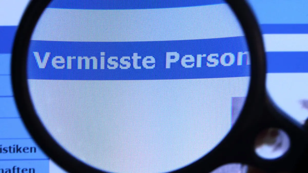 ARCHIV - 27.08.2010, Mecklenburg-Vorpommern, Schwerin: Hinter einer Lupe ist der Schriftzug «Vermisste Person» auf einem Fahndungsaufruf auf der Internetseite des Bundeskriminalamtes (BKA) zu sehen. (zu dpa: «Mehr Langzeit-Vermisste in NRW») Foto: Jens Büttner/dpa +++ dpa-Bildfunk +++