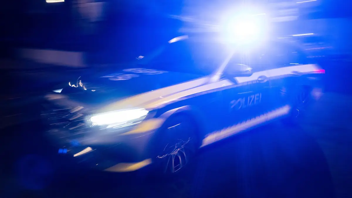 ILLUSTRATION - 30.11.2023, Baden-Württemberg, Stuttgart: Ein Polizeifahrzeug fährt mit Blaulicht an einem Gebäude vorbei. (zu dpa: «Brand in Bankfiliale nach Sprengung eines Geldautomaten») Foto: Marijan Murat/dpa +++ dpa-Bildfunk +++
