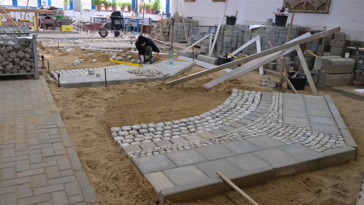 Im Ausbildungsbereich für Vermessungstechnik, Tief- und Straßenbau gibt es "den größten Sandkasten der Region", und zwar ohne Boden. So lernen Tiefbauer unter realistischen Bedingungen. Zu sehen ist hier das Abschlussstück eines Straßenbauers für die Abschlussprüfung.