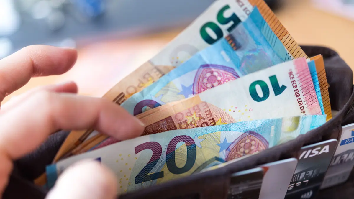 ARCHIV - 04.12.2018, Sachsen, Dresden: ILLUSTRATION - Eine Frau hält eine Geldbörse mit zahlreichen Banknoten und Bankkarten in der Hand (gestellte Szene). (zu "Konferenz zum Solidarischen Grundeinkommen" vom 19.02.2019) Foto: Monika Skolimowska/ZB/dpa +++ dpa-Bildfunk +++