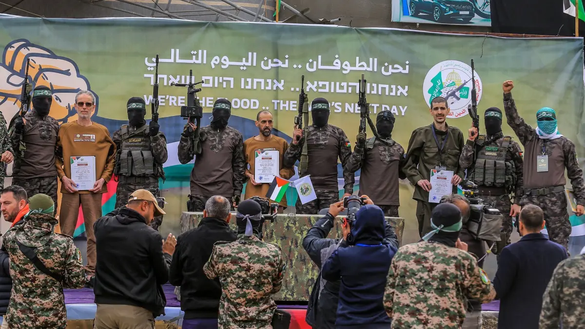 Nahostkonflikt - Drei Geiseln in Deir al-Balah freigelassen: 08.02.2025, Palästinensische Gebiete, Deir al-Balah: Kämpfer der Al-Kassam-Brigaden, des militärischen Flügels der islamistischen Terrororganisation Hamas, übergeben die drei israelischen Geiseln Or Levy (r), Eli Scharabi (M) und Ohad Ben Ami (l) nach 16 Monaten Geiselhaft im Rahmen eines Waffenruhe-Abkommens zwischen Israel und der Hamas an Vertreter des Internationalen Komitees vom Roten Kreuz (IKRK). Ihr abgemagertes und blasses Aussehen sorgte in Israel für Entsetzen. Foto: Abed Rahim Khatib/dpa +++ dpa-Bildfunk +++