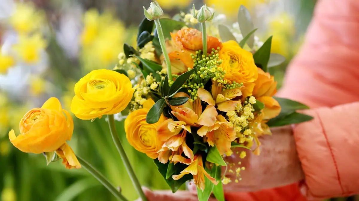 Floristin bindet einen Blumenstrauß: ARCHIV - Statt rote Rosen: Wer im Blumenladen kauft, statt online zu bestellen, kann den Strauß nach individuellen Vorlieben zusammenstellen. (zu dpa: «So wählt und pflegt man den perfekten Blumenstrauß») Foto: Roland Weihrauch/dpa/dpa-tmn - Honorarfrei nur für Bezieher des dpa-Themendienstes +++ dpa-Themendienst +++
