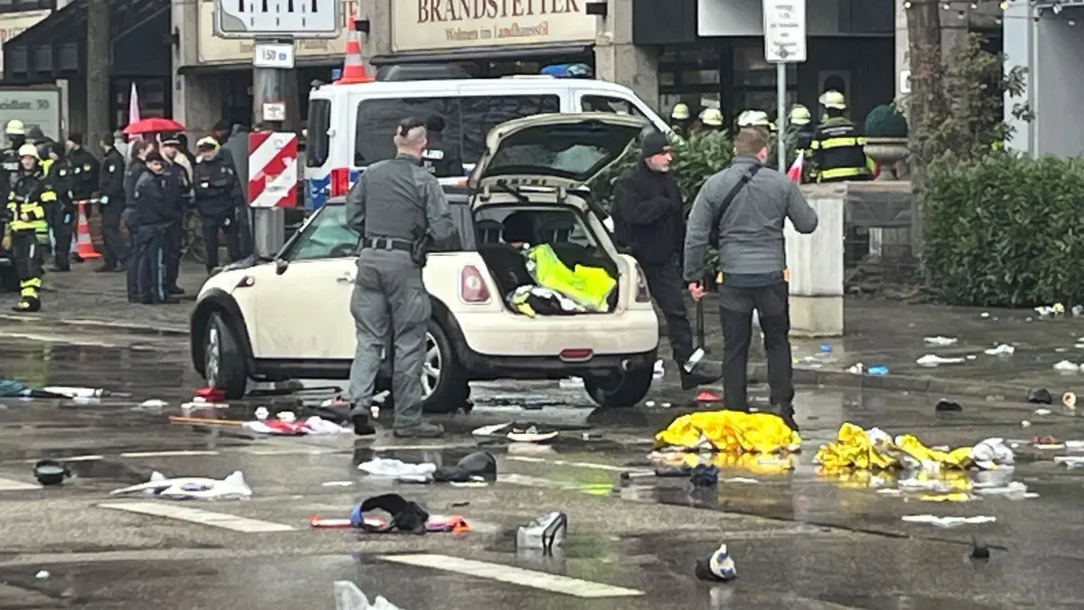 Auto in München in Menschengruppe gefahren: 13.02.2025, Bayern, München: Polizisten untersuchen ein Auto in der Nähe des Einsatzortes. In der Münchner Innenstadt ist ein Fahrzeug in eine Menschengruppe gefahren. Wie die Polizei auf der Plattform X mitteilte, wurden mehrere Menschen verletzt. Foto: Christoph Trost/dpa +++ dpa-Bildfunk +++