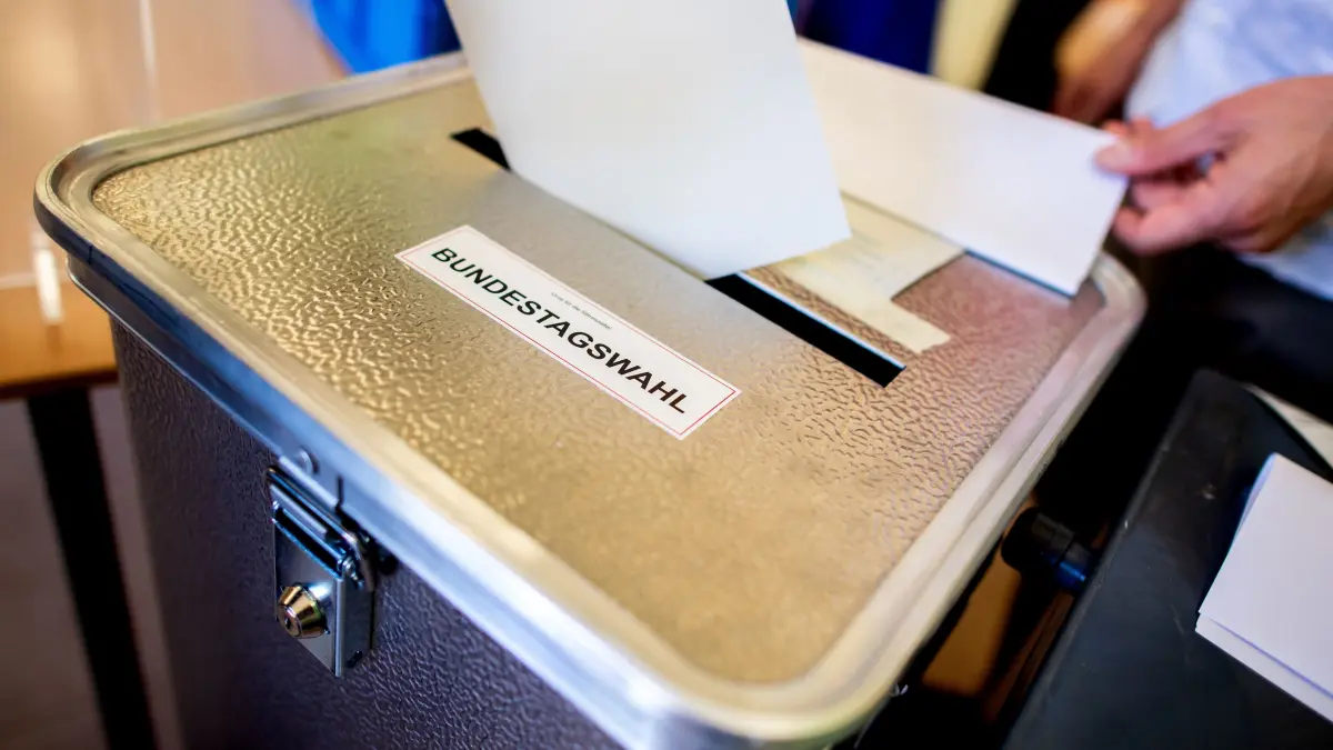 Ein Wähler wirft in einem Wahllokal seinen Stimmzettel für die Bundestagswahl 2025 in eine Wahlurne. In Oranienburg wurde gegen den bundesdeutschen Trend gewählt.