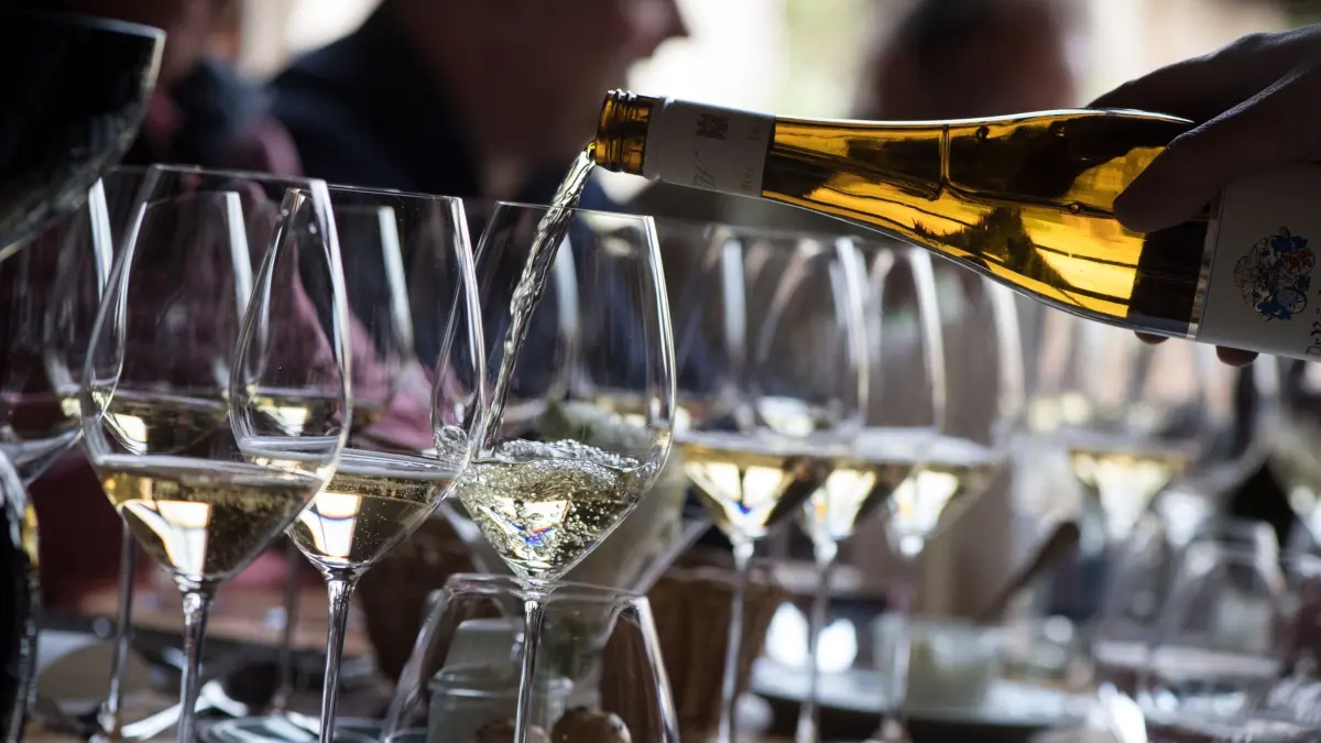 Sekt wird während eines Essens eingeschenkt: ARCHIV - Alkohol ist ein Risikofaktor für die Gesundheit unseres Herzens. (zu dpa: «Stolpert da was? Herzrhythmusstörungen frühzeitig erkennen») Foto: Franziska Gabbert/dpa-tmn - Honorarfrei nur für Bezieher des dpa-Themendienstes +++ dpa-Themendienst +++