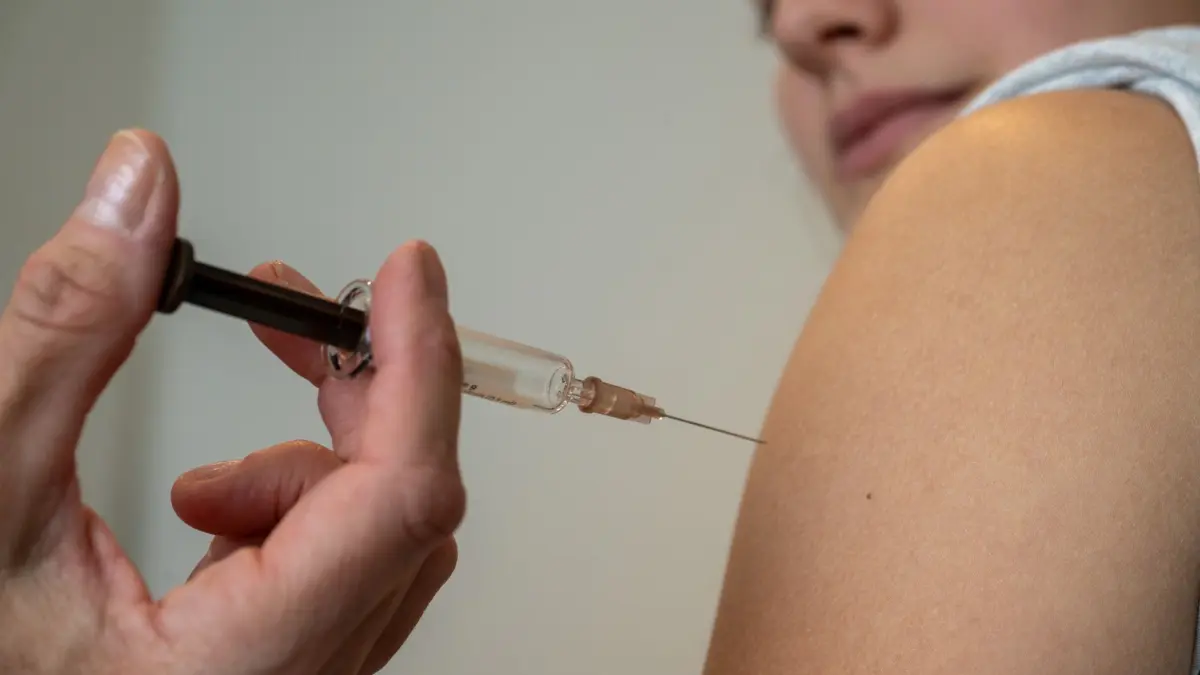 HPV-Impfung in einer Frauenarztpraxis: ARCHIV - 12.12.2023, Bayern, Planegg: Gynäkologin Stephanie Eder setzt bei der HPV-Impfung in einer Frauenarztpraxis eine Injektion in den Oberarm einer Jugendlichen. (zu dpa: «Infektiologe: Corona-Pandemie hat Impfskepsis vergrößert») Foto: Stefan Puchner/dpa +++ dpa-Bildfunk +++