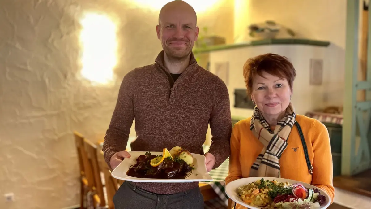 Foto 2 Robert und Hannelore Motzek vom Kräutermühlenhof in Burg im Spreewald, er hält einen Teller mit Hirschbraten, sie hält einen Teller mit Kichererbsencurry am 25.02.2025