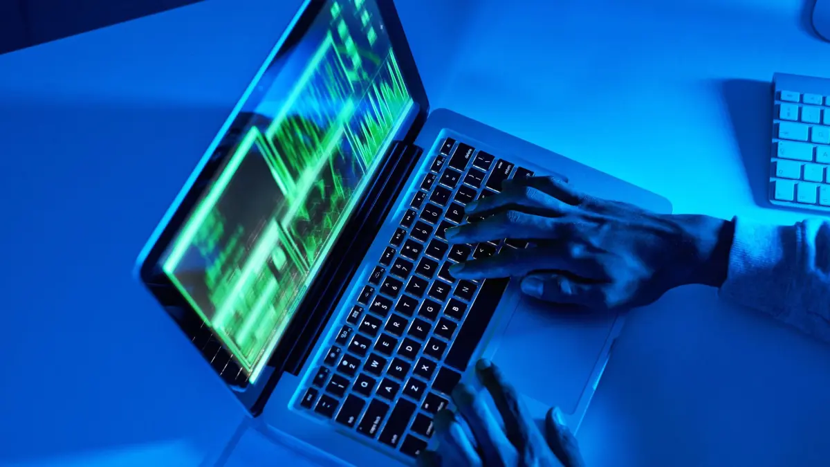 Hands, fraud or hacker on laptop for cybercrime scam, malware or phishing online data in dark. Programmer, person or above of pc software update on tech for hacking private server on website in night. model released / property released Copyright: xwww.peopleimages.comx