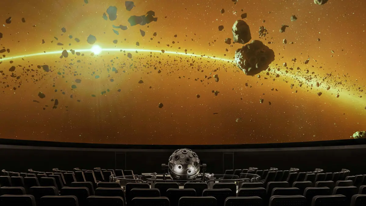Asteroiden fliegen auf der Leinwand unter der gewölbten Kuppel des Zeiss Großplanetariums durch das Sonnensystem.