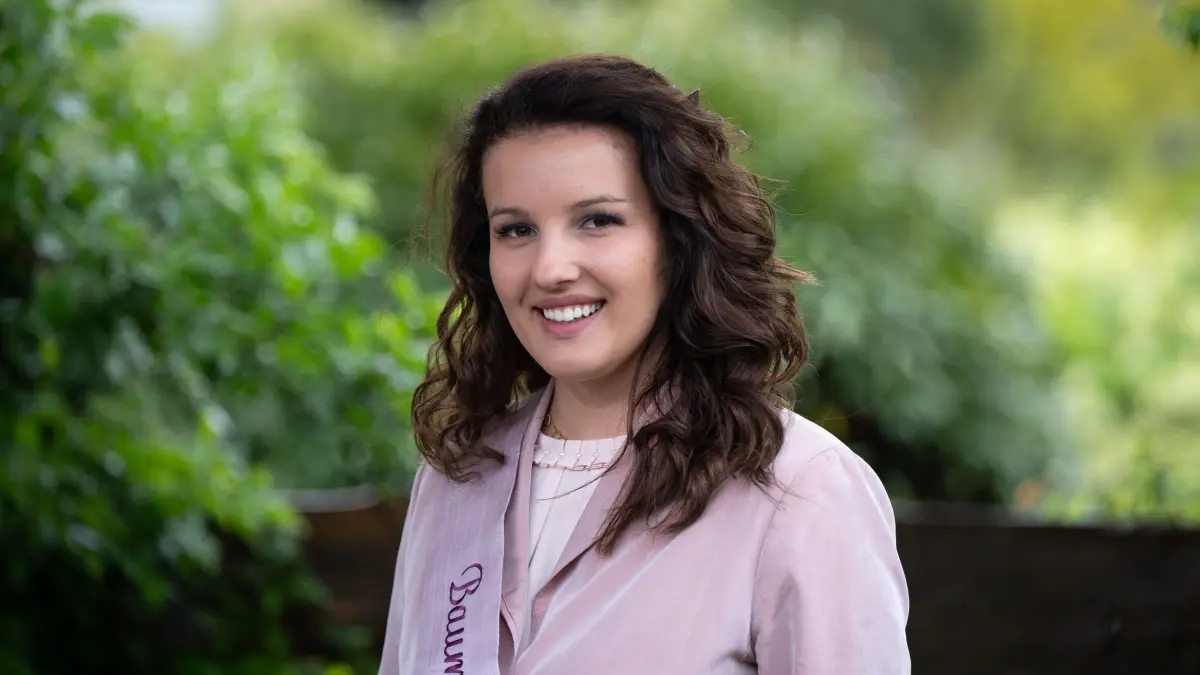 Theresa Tauchert, Baumblütenkönigin 2024 von Werder an der Havel, steht nach einer Pressekonferenz zum Programm des 145. Baumblütenfestes im Garten vom Cafe Hagemeister. Die angehende Meisterin für Sanitär-, Heizungs- und Klimatechnik wurde bei der Königinnenwahl unter fünf Bewerberinnen ausgewählt.