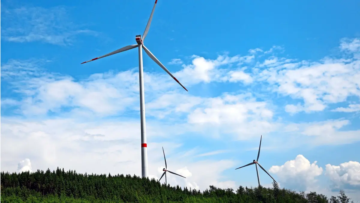 ARCHIV - 06.06.2023, Nordrhein-Westfalen, Bad Berleburg: Wolken ziehen über Windräder zur Stromerzeugung. In Nordrhein-Westfalen wird es für sechs Monate ein Genehmigungsmoratorium für Windkraftanlagen außerhalb bestimmter Planungszonen geben. (zu dpa: «Umstrittenes Genehmigungslimit für Windanlagen beschlossen») Foto: Federico Gambarini/dpa +++ dpa-Bildfunk +++