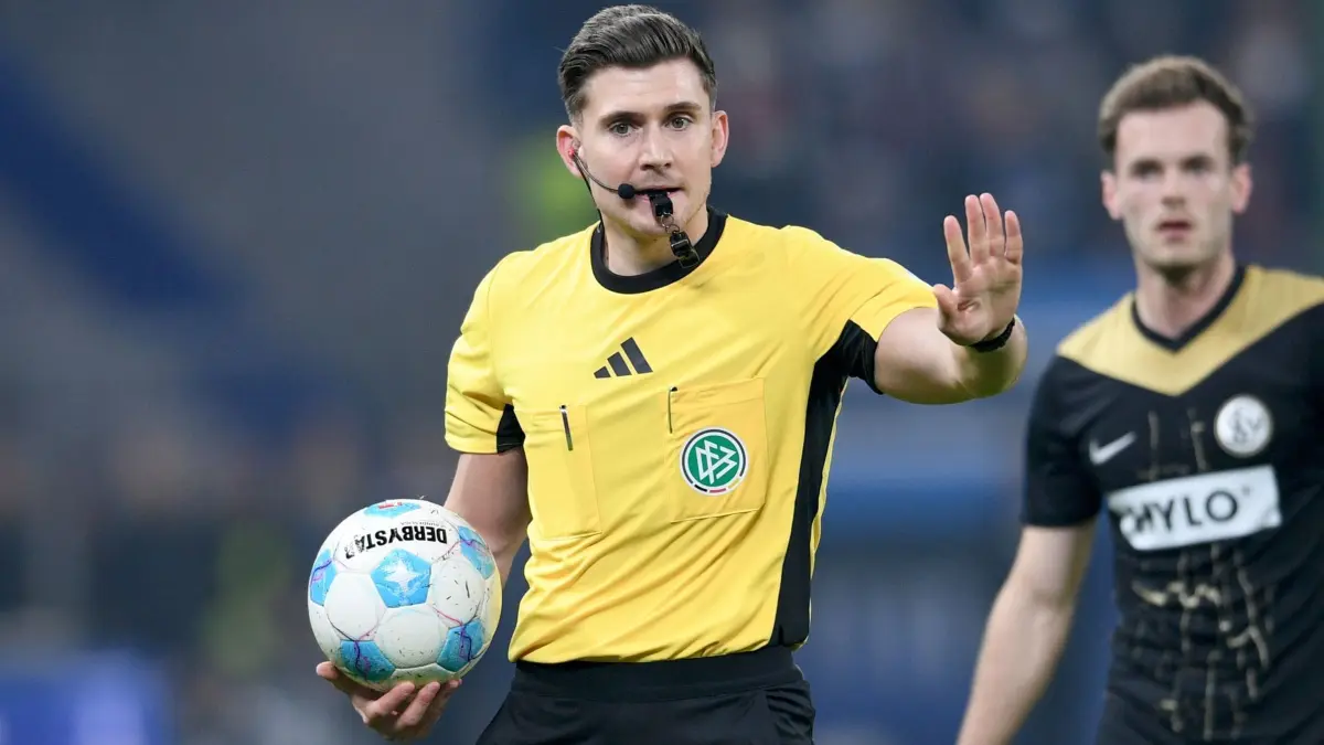 Hamburger SV - SV Elversberg: 28.03.2025, Hamburg: Fußball: 2. Bundesliga, Hamburger SV - SV Elversberg, 27. Spieltag, Volksparkstadion. Schiedsrichter Felix Prigan gibt Anweisungen. WICHTIGER HINWEIS: Gemäß den Vorgaben der DFL Deutsche Fußball Liga bzw. des DFB Deutscher Fußball-Bund ist es untersagt, in dem Stadion und/oder vom Spiel angefertigte Fotoaufnahmen in Form von Sequenzbildern und/oder videoähnlichen Fotostrecken zu verwerten bzw. verwerten zu lassen. Foto: Michael Schwartz/dpa +++ dpa-Bildfunk +++