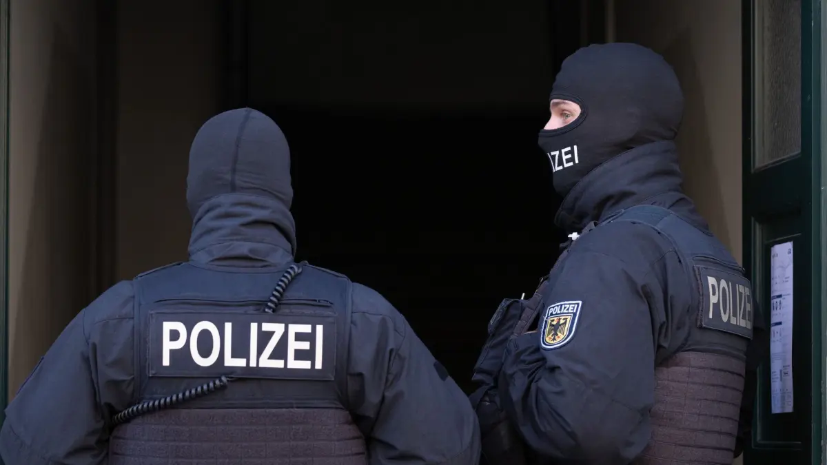 05.11.2024, Sachsen, Dresden: Polizisten stehen während einer Razzia gegen mutmaßliche Rechtsextreme in einem Hauseingang im Dresdner Stadtteil Cotta. Die Bundesanwaltschaft hat acht mutmaßliche Rechtsterroristen in Sachsen und Polen festnehmen lassen. Gleichzeitig werden rund 20 Objekte durchsucht, wie die Karlsruher Behörde mitteilte. Auch in Österreich finden Durchsuchungen statt. Foto: Sebastian Kahnert/dpa - ACHTUNG: Person(en) wurde(n) aus rechtlichen Gründen gepixelt +++ dpa-Bildfunk +++