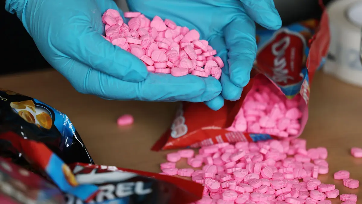 Drogen: ARCHIV - 15.06.2021, Nordrhein-Westfalen, Köln: Ein Zollbeamter hält Ecstasy Tabletten in der Hand, die am Flughafen Köln/Bonn sichergestellt wurden. (zu dpa: «Tödliche Mischung: So viele Drogentote wie lange nicht mehr») Foto: Oliver Berg/dpa +++ dpa-Bildfunk +++