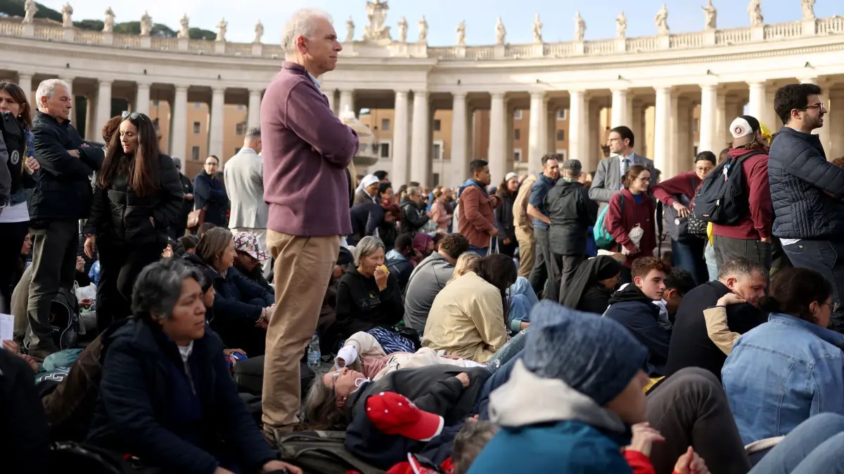Papst Franziskus gestorben - Beisetzung: 26.04.2025, Vatikan, Vatikanstadt: Gläubige haben sich vor Beginn der Trauermesse für den verstorbenen Papst Franziskus auf dem Petersplatz versammelt. Nach der Trauerfeier und dem Trauerzug mit dem Sarg durch die Straßen wird der Leichnam in der Basilika Santa Maria Maggiore beigesetzt. Foto: Oliver Weiken/dpa +++ dpa-Bildfunk +++
