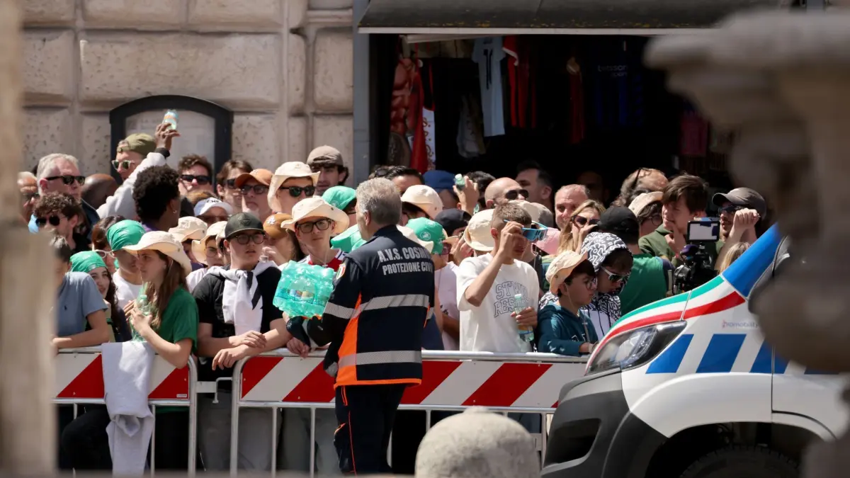 Papst Franziskus gestorben - Beisetzung: 26.04.2025, Italien, Rom: Wasser wird an die wartenden Menschen an der Strecke des Trauerzug mit dem Sarg des verstorbenen Papst Franziskus verteilt. Foto: Christoph Reichwein/dpa +++ dpa-Bildfunk +++