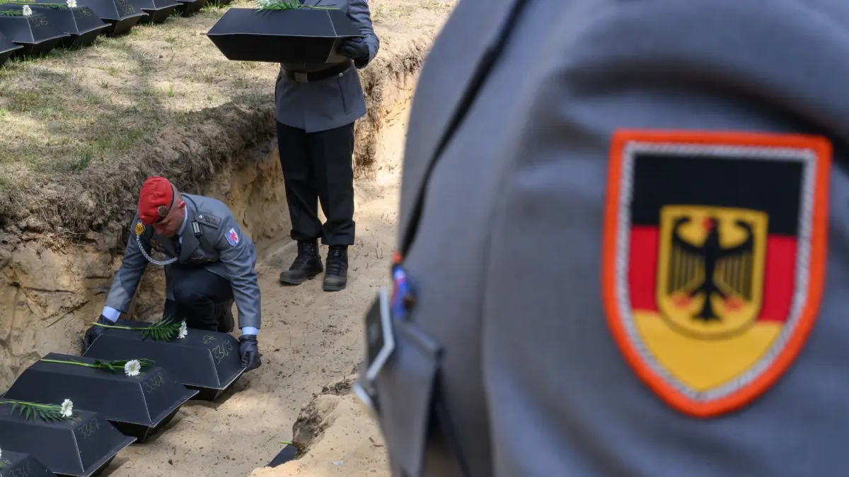 Einbettung von deutschen Kriegstoten des Zweiten Weltkrieges: 30.04.2025, Brandenburg, Halbe: Soldaten der Bundeswehr betten kleine Särge mit den sterblichen Überresten deutscher Soldaten aus dem Zweiten Weltkrieg bei einer Gedenkveranstaltung des Volksbundes Deutsche Kriegsgräberfürsorge e.V. auf dem Waldfriedhof Halbe ein. 80 Jahre nach Ende des Zweiten Weltkrieges fanden 100 deutsche Soldaten ihre letzte würdige Ruhestätte auf Deutschlands größter Kriegsgräberstätte. Bei den Kämpfen kurz vor Kriegsende im April 1945 verloren viele tausende Soldaten vor den Toren Berlins ihr Leben. Foto: Patrick Pleul/dpa +++ dpa-Bildfunk +++