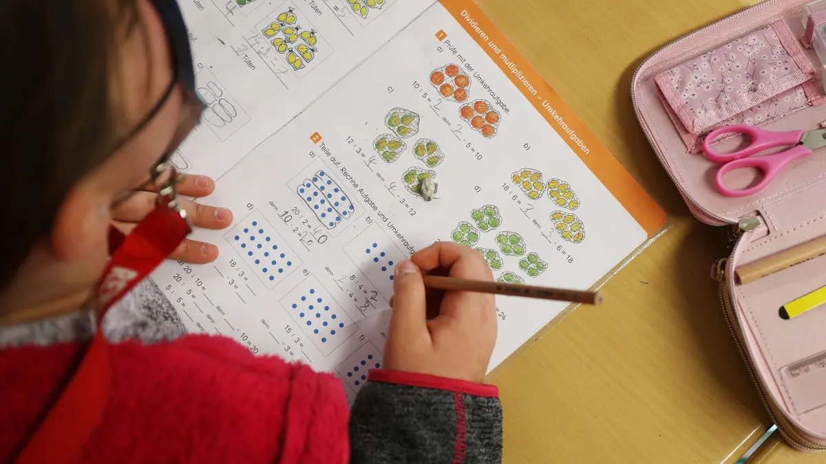 Unterricht in der Grundschule: ACHTUNG: SPERRFRIST 21. MAI 18:00 UHR. - ARCHIV - 28.03.2022, Nordrhein-Westfalen, Swisttal: Eine Schülerin schreibt im Unterricht in ihr Schulbuch und löst eine Rechenaufgabe.
(zu dpa: «Schulleitungen im Brennpunkt sehen Defizite und Hürden») Foto: Oliver Berg/dpa +++ dpa-Bildfunk +++