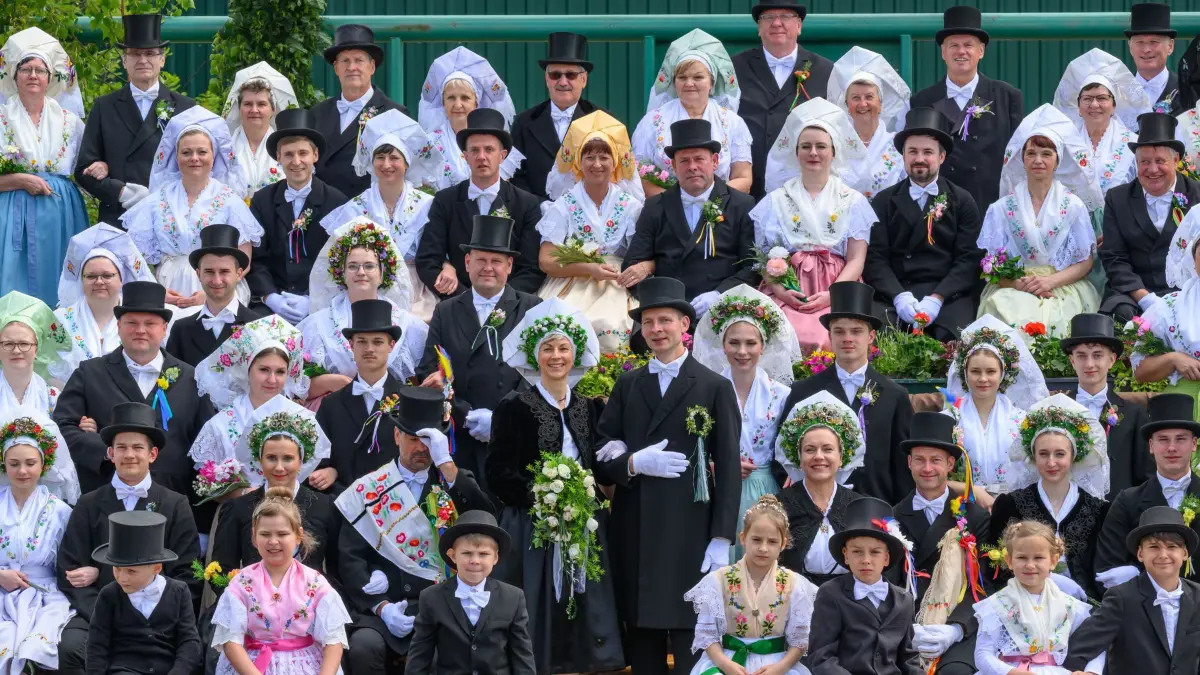 Sorben feiern 50 Jahre Hochzeitszug: 24.05.2025, Brandenburg, Heinersbrück: Für ein Gruppenbild haben sich Personen in sorbischen Trachten beim Festumzug anlässlich 50 Jahre Hochzeitszug im Lausitzdorf Heinersbrück aufgestellt. Ein Hochzeitszug bei den Sorben ist eine traditionelle Zeremonie, bei der das Brautpaar und die Hochzeitsgäste in Trachten und oft auch in speziellen Rollen durch einen Ort ziehen. Der Zug wird vom Hochzeitsbitter angeführt, gefolgt vom Bräutigam und der Braut. Foto: Patrick Pleul/dpa +++ dpa-Bildfunk +++