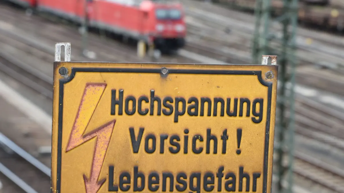 Lebensgefahr durch Oberleitungen: ARCHIV - 18.05.2015, Hessen, Gießen: Auf einer Brücke über den Gleisanlagen am Bahnhof in Gießen ist ein Warnschild mit der Aufschrift «Hochspannung Vorsicht ! Lebensgefahr» angebracht. (zu dpa: «19-Jähriger stirbt durch Stromschlag auf Güterwaggon») Foto: Arne Dedert/dpa +++ dpa-Bildfunk +++