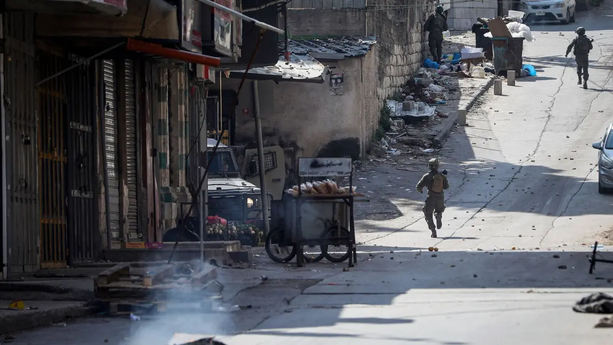 Nahostkonflikt: ARCHIV - 16.02.2025, Palästinensische Gebiete, Ramallah: Israelische Soldaten gehen während einer Militärrazzia in der Altstadt von Nablus im besetzten Westjordanland eine Straße entlang. (zu dpa: «Palästinenser: Israel tötet 14-Jährigen im Westjordanland») Foto: Ayman Nobani/dpa +++ dpa-Bildfunk +++
