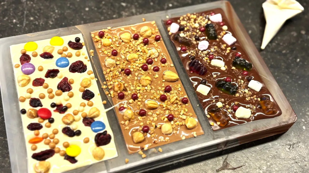 So gestalten Besucher der Confiserie Felicitas ihre Schokoladen in der Form.