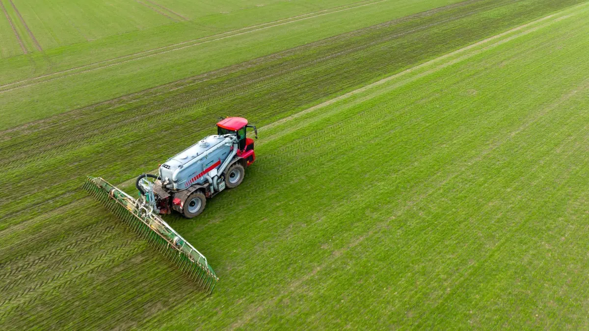 Landwirtschaft: ARCHIV - 15.02.2022, Niedersachsen, Vorwerk: Ein Landwirt bringt mit seinem Gespann Gülle im sogenannten Schleppschuh Verfahren auf einem Feld aus (Aufnahme mit einer Drohne). (zu dpa: «Entlastung für Bauern bei Dünge-Vorschriften») Foto: Philipp Schulze/dpa +++ dpa-Bildfunk +++