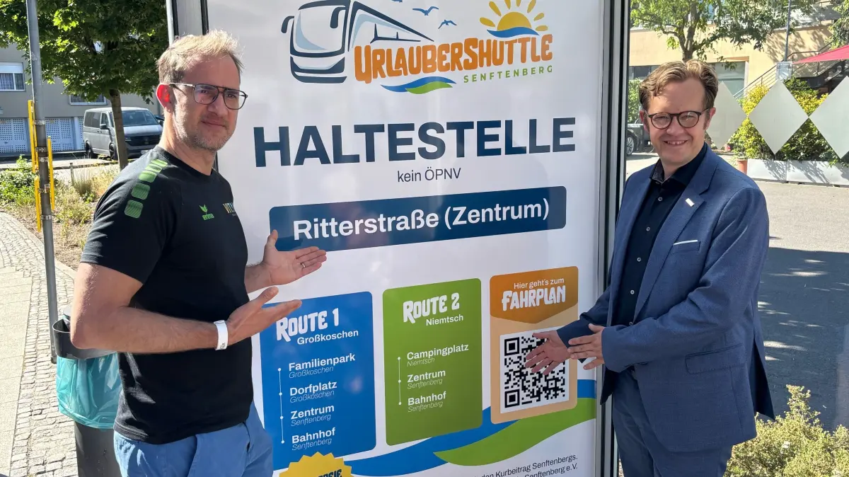 Hier präsentieren Jan Przybilski vom Gewerbeverein sowie Bürgermeister Andreas Pfeiffer die eigens für den Urlaubershuttle gestaltete Bushaltestelle in der Ritterstraße am Schlossparkcenter.