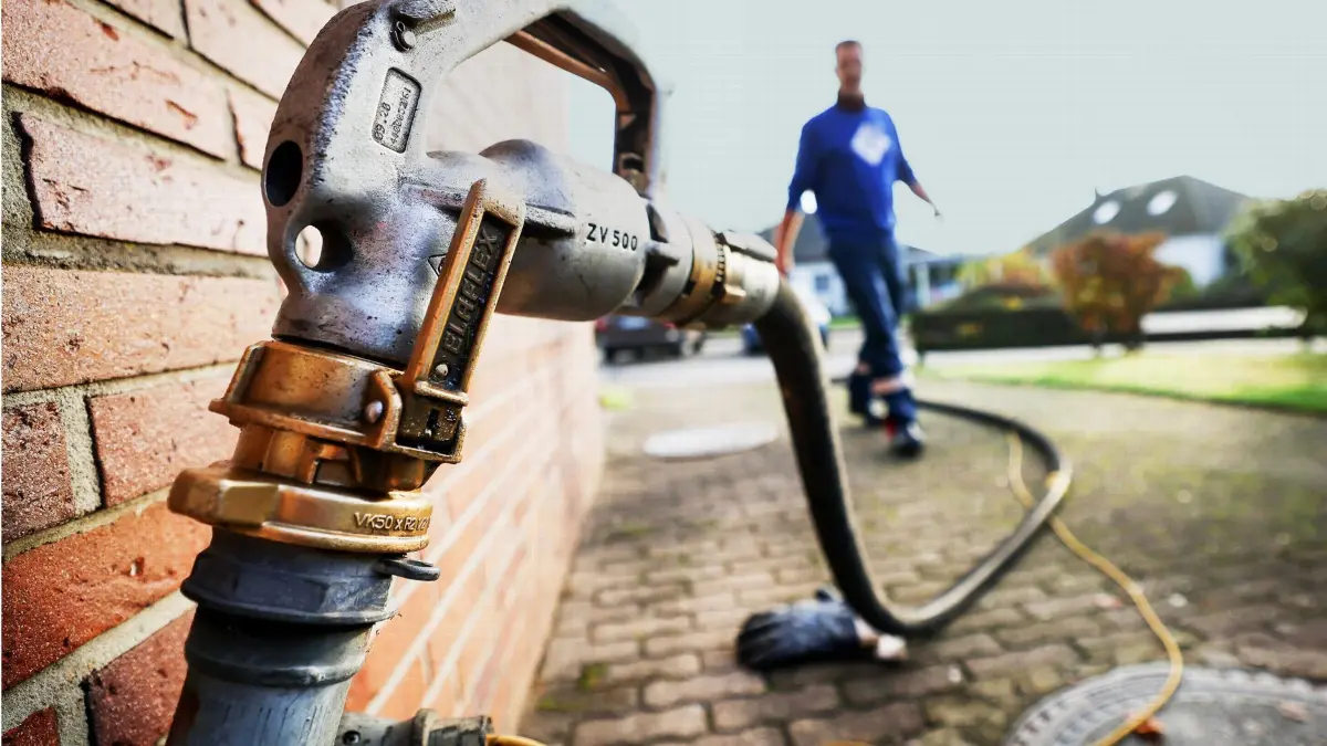 ARCHIV - 09.11.2021, Schleswig-Holstein, Itzehoe: Ein Mitarbeiter eines Diesel- und Heizöl-Unternehmens geht zur Zapfpistole an einem Füllstutzen für die Heizöllieferung an einen Kunden in einem Einfamilienhaus. Die Ampel-Fraktionen im Bundestag haben sich auf Entlastungen auch für Menschen geeinigt, die zum Beispiel mit Öl oder Pellets heizen. (zu dpa «Entlastungen nun auch für Verbraucher mit Öl- und Pelletheizungen») Foto: Christian Charisius/dpa +++ dpa-Bildfunk +++