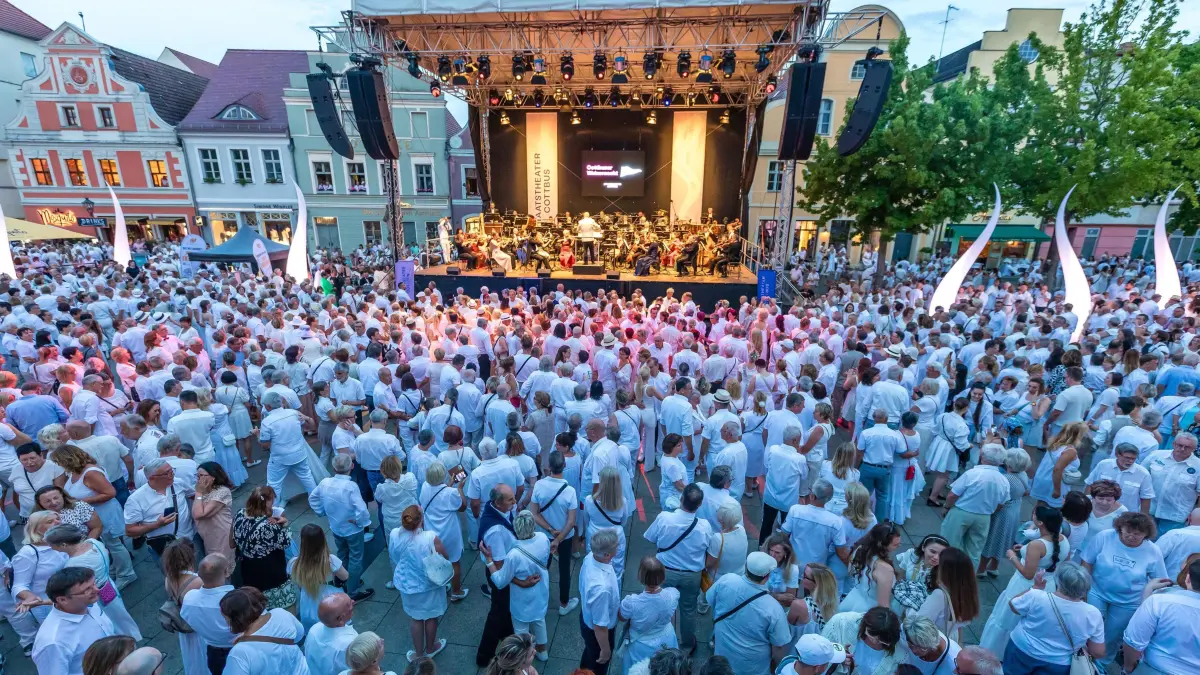 Walzernacht auf dem Cottbuser Altmarkt: Hunderte Menschen tanzen auf dem Cottbuser Altmarkt bei der Cottbuser Walzernacht. Auf der Bühne spielt das Philharmonische Orchester des Staatstheaters.