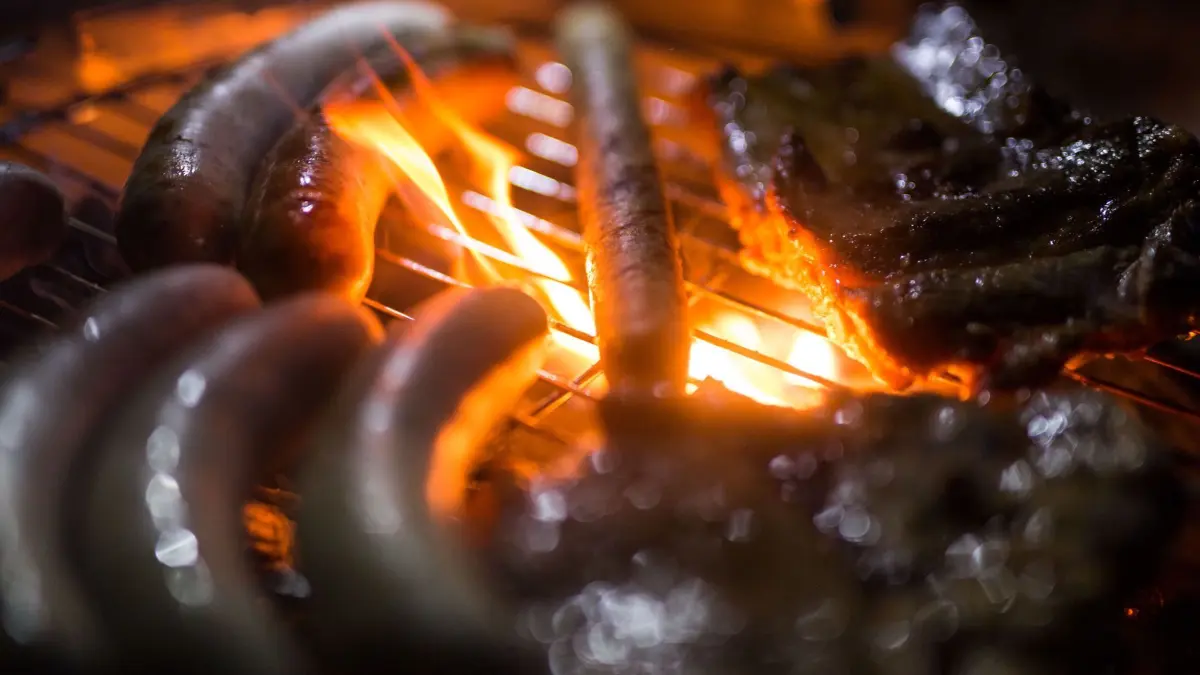Grillen: ARCHIV - 09.03.2017, Schleswig-Holstein, Wangels: Flammen umspielen Grillfleisch und Würstchen auf einem Grill. Beim Grillen in einem Mainzer Park hat sich ein Mann schwere Verbrennungen zugezogen, ein weiterer erlitt Verbrennungen im Gesicht und an der Hand. Foto\ Lino Mirgeler/dpa (zu dpa: «Grillspaß ohne Desaster - darauf kommt es an») Foto: Lino Mirgeler/dpa +++ dpa-Bildfunk +++
