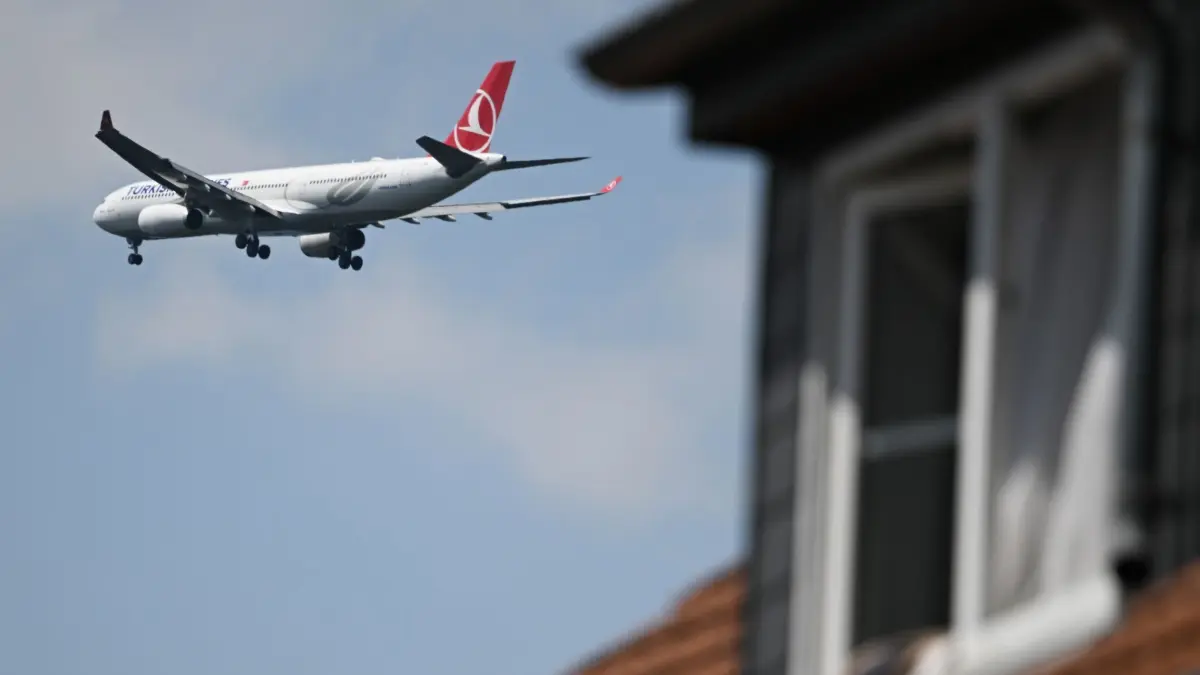 Flugzeug über Neu-Isenburg: ARCHIV - 22.07.2024, Hessen, Neu-Isenburg: Ein Airbus A 330 der Turkish Airlines ist hinter einem Haus im Landeanflug auf den Frankfurter Flughafen. Hunderttausende Menschen sind rund um Frankfurt von Fluglärm betroffen. Zur Ferienzeit wird es nun noch etwas lauter. Als Gegenmaßnahme haben Bürgerinitiativen Kurzstrecken-Flüge im Visier. (zu dpa: «Flugrouten-Pläne machen Ministerin fassungslos») Foto: Arne Dedert/dpa +++ dpa-Bildfunk +++