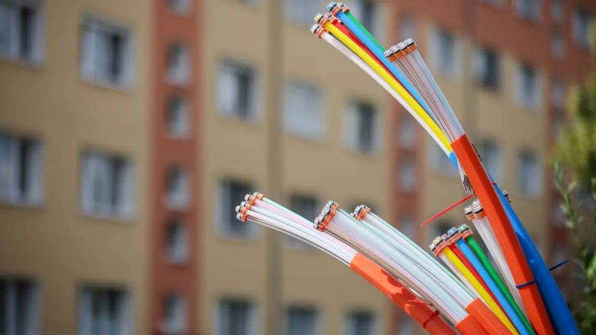 Glasfaser-Kabel: ARCHIV - 26.07.2023, Sachsen, Zwenkau: Aus dem Sockel eines Schaltschranks ragen Glasfaserkabel heraus. Die Bundesnetzagentur sieht kein wettbewerbswidriges Verhalten der Deutschen Telekom beim Glasfaserausbau. (zu dpa: «Netzagentur beendet Streit um doppelten Glasfaserausbau») Foto: Jan Woitas/dpa +++ dpa-Bildfunk +++