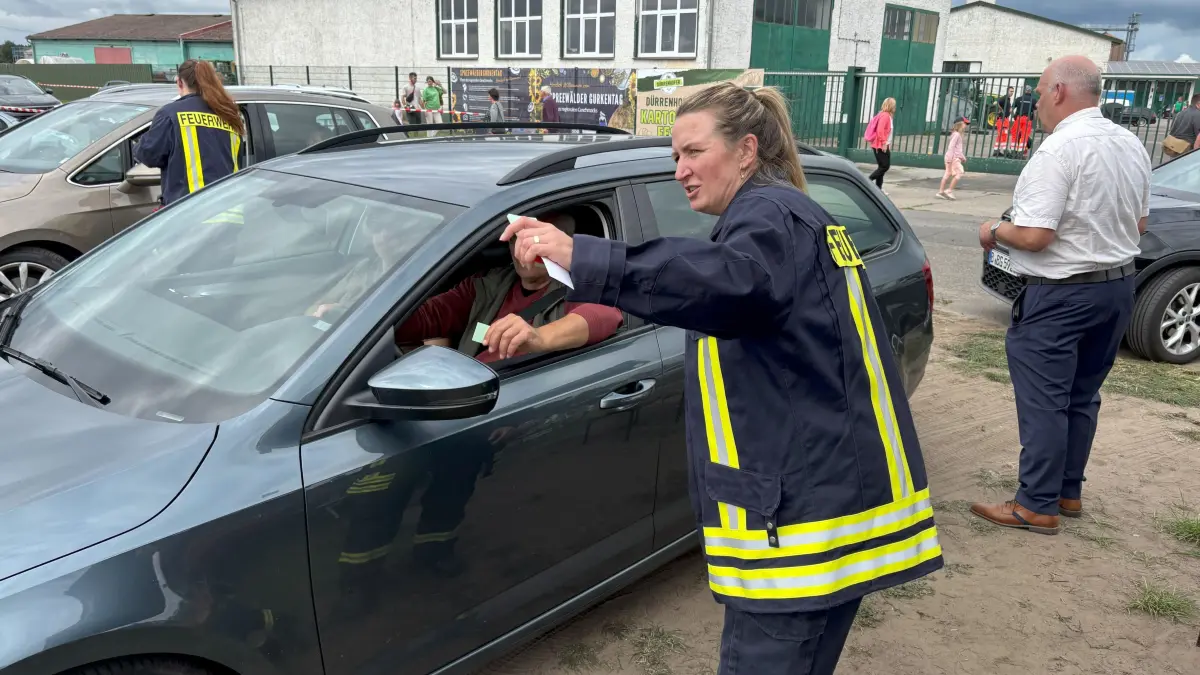 Jenny Dillan von der Freiwlligen Feuerwehr Dürrenhofe weist die Fahrzeuglenker am Eingang des Parkplatzes ein.