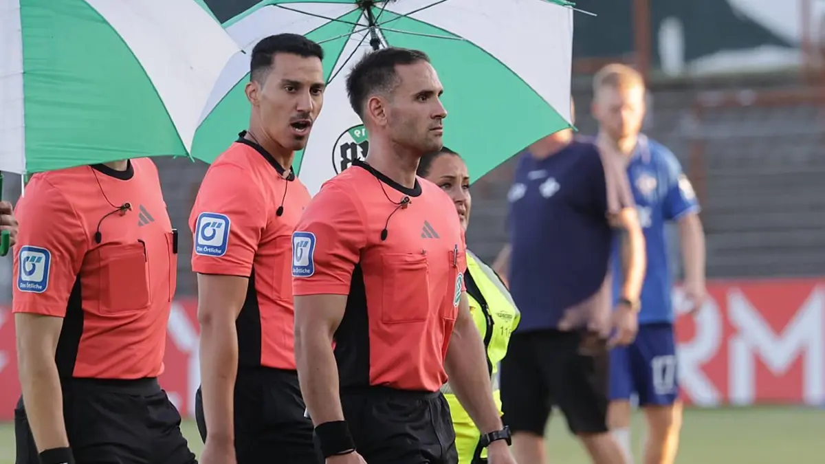 Schiedsrichter Leonidas Exuzidis (SC Victoria Ickern) muss beim Verölassen des Spielfeldes geschuetzt werden Fussball, S: Schiedsrichter Leonidas Exuzidis SC Victoria Ickern muss beim Verölassen des Spielfeldes geschuetzt werden Fussball, Saison 2025/2026, Maenner, Herren, DFB Pokal, 1. Hauptrunde, VfB Luebeck gegen SV Darmstadt 98, 1-2 DFL REGULATIONS PROHIBIT ANY USE OF PHOTOGRAPHS AS IMAGE SEQUENCES AND/OR QUASI-VIDEO. *** Referee Leonidas Exuzidis SC Victoria Ickern must be protected when leaving the pitch Football, Season 2025 2026, Men, Men, DFB Pokal, 1 Main Round, VfB Luebeck vs SV Darmstadt 98, 1 2 DFL REGULATIONS PROHIBIT ANY USE OF PHOTOGRAPHS AS IMAGE SEQUENCES AND OR QUASI VIDEO