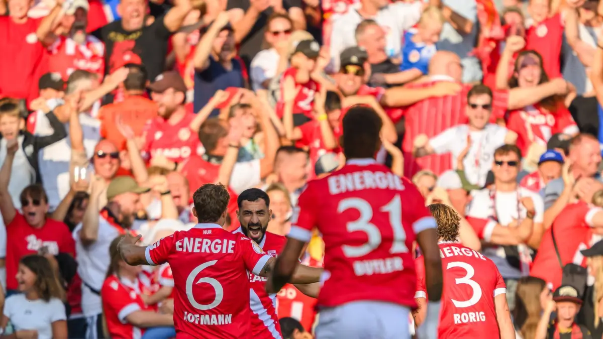 FC Energie Cottbus - Hannover 96: 16.08.2025, Brandenburg, Cottbus: Fußball: DFB-Pokal, FC Energie Cottbus - Hannover 96, 1. Runde, LEAG Energie Stadion, Tolcay Cigerci (Energie Cottbus, 2.v.l) jubelt nach seinem Tor zum 1:0 mit Jonas Hofmann (Energie Cottbus, l-r), Justin Butler (Energie Cottbus) und Henry Rorig (Energie Cottbus). Foto: Robert Michael/dpa - WICHTIGER HINWEIS: Gemäß den Vorgaben der DFL Deutsche Fußball Liga bzw. des DFB Deutscher Fußball-Bund ist es untersagt, in dem Stadion und/oder vom Spiel angefertigte Fotoaufnahmen in Form von Sequenzbildern und/oder videoähnlichen Fotostrecken zu verwerten bzw. verwerten zu lassen. +++ dpa-Bildfunk +++