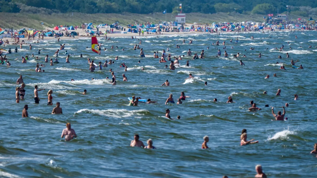 Insel Usedom: ARCHIV - 13.08.2025, Mecklenburg-Vorpommern, Zinnowitz: Touristen halten sich bei Sonne und hochsommerlichen Temperaturen im Ostseebad am Strand und im Wasser auf. (zu dpa: «Usedom: 82-Jähriger stirbt beim Baden, aber nicht ertrunken») Foto: Stefan Sauer/dpa +++ dpa-Bildfunk +++