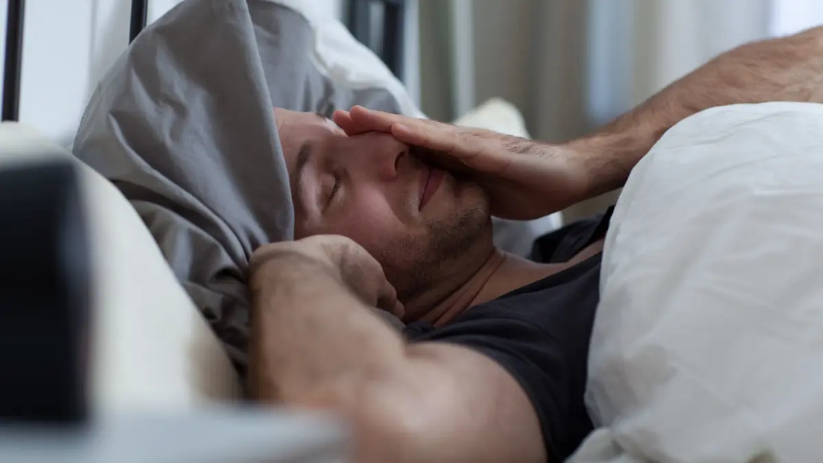 Ein Mann liegt mit Schlafstörungen im Bett: ILLUSTRATION - Schlafprobleme infolge des Jetlags können einem am Reiseziel länger begleiten. (zu dpa: «Kampf mit innerer Uhr: Wie Jetlag entsteht – und was hilft») Foto: Christin Klose/dpa-tmn - Honorarfrei nur für Bezieher des dpa-Themendienstes +++ dpa-Themendienst +++