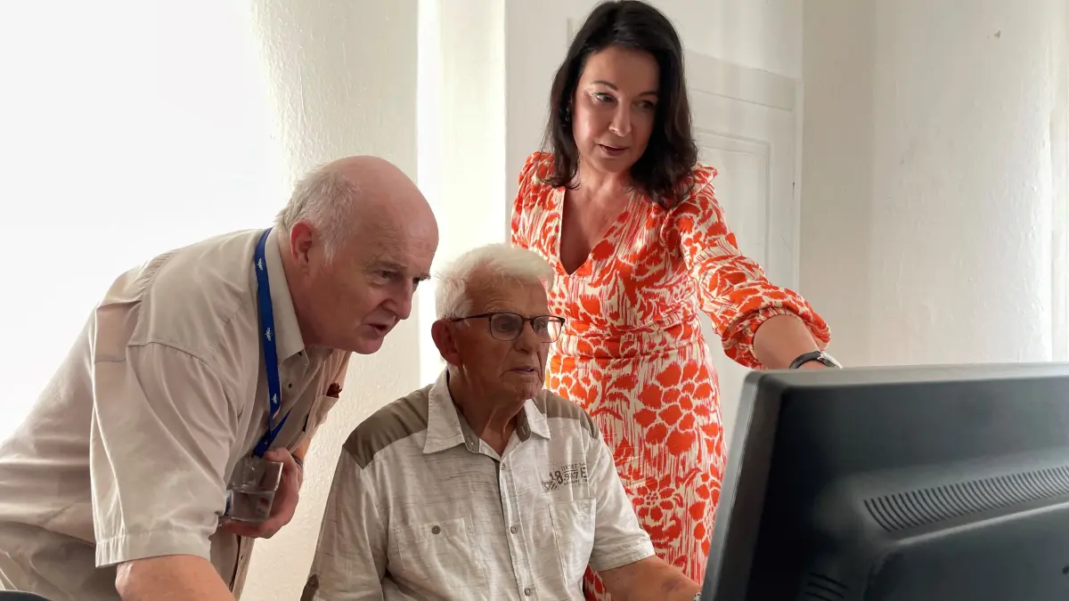 Sozialministerin Britta Müller mit dem Projektverantwortlichen Ulrich Hermenau (links) zeigen dem 93-jährigen Scholz aus Zeuthen ein Programm am Schulungscomputer im Digital Café in Zeuthen.