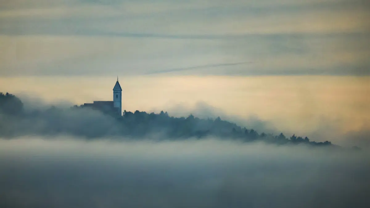 Wetter in Baden-Württemberg: 07.09.2025, Baden-Württemberg, Riedlingen: Blick auf die aus dem Nebel ragende Wallfahrtskirche auf dem Berg "Bussen" in Oberschwaben. Im Hintergrund erhellt die Sonne den Himmel. Foto: Thomas Warnack/dpa +++ dpa-Bildfunk +++