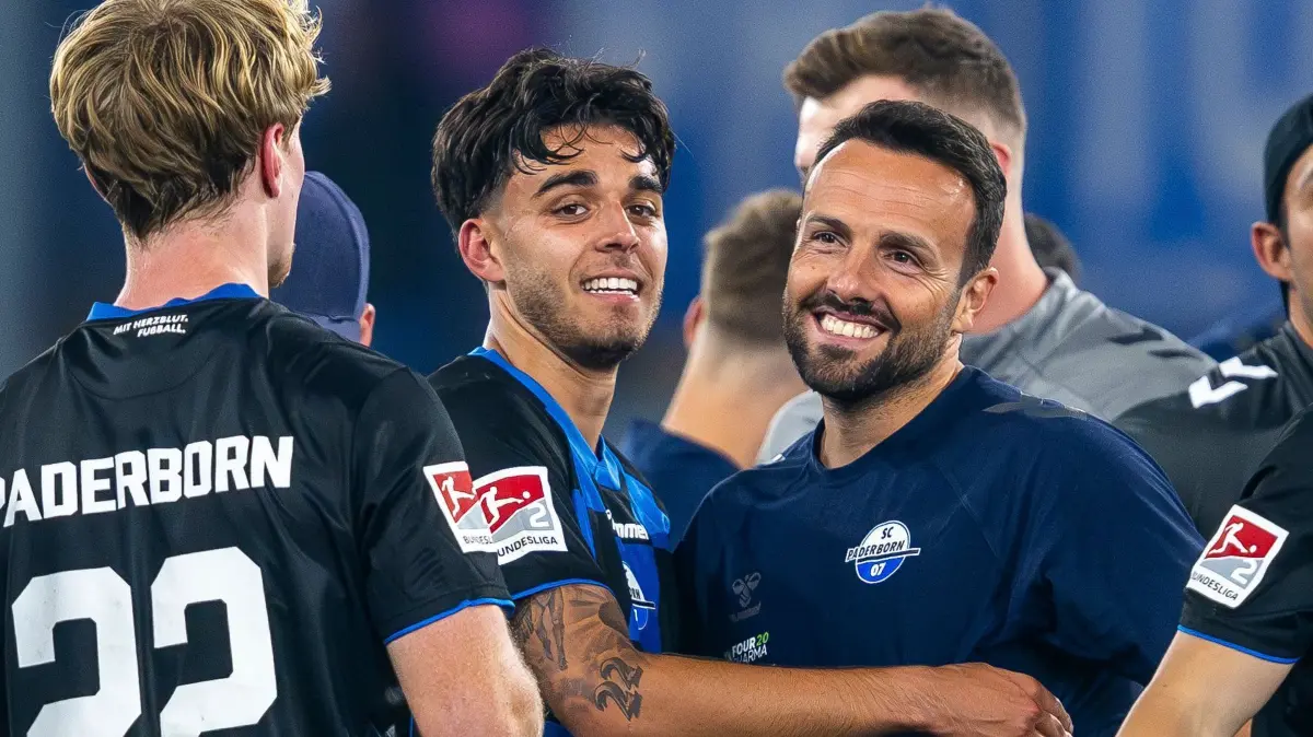 SC Paderborn 07 - VfL Bochum: 12.09.2025, Nordrhein-Westfalen, Paderborn: Fußball: 2. Bundesliga, SC Paderborn 07 - VfL Bochum, 5. Spieltag, Home Deluxe Arena: Lucas Copado (SC Paderborn 07) (l) umarmt Trainer Ralf Kettemann (SC Paderborn 07). Foto: David Inderlied/dpa - WICHTIGER HINWEIS: Gemäß den Vorgaben der DFL Deutsche Fußball Liga bzw. des DFB Deutscher Fußball-Bund ist es untersagt, in dem Stadion und/oder vom Spiel angefertigte Fotoaufnahmen in Form von Sequenzbildern und/oder videoähnlichen Fotostrecken zu verwerten bzw. verwerten zu lassen. +++ dpa-Bildfunk +++