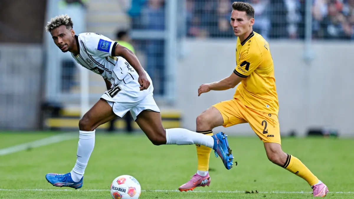 SV Elversberg - Dynamo Dresden: 14.09.2025, Saarland, Spiesen-Elversberg: Fußball: 2. Bundesliga, SV Elversberg - Dynamo Dresden, 5. Spieltag, Ursapharm-Arena an der Kaiserlinde. Bambasé Conté (l, SV 07 Elversberg) und Konrad Faber (Dynamo Dresden) kämpfen um den Ball. Foto: Uwe Anspach/dpa - WICHTIGER HINWEIS: Gemäß den Vorgaben der DFL Deutsche Fußball Liga bzw. des DFB Deutscher Fußball-Bund ist es untersagt, in dem Stadion und/oder vom Spiel angefertigte Fotoaufnahmen in Form von Sequenzbildern und/oder videoähnlichen Fotostrecken zu verwerten bzw. verwerten zu lassen. +++ dpa-Bildfunk +++