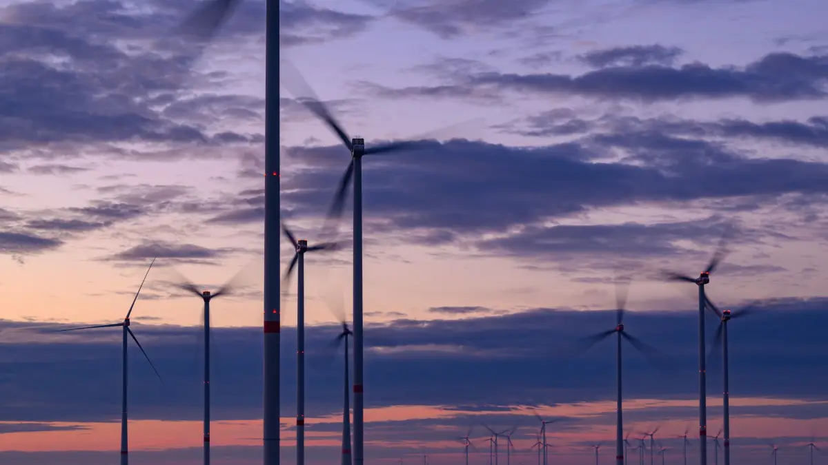 Ausbau erneuerbarer Energien: ARCHIV - 08.10.2024, Brandenburg, Sieversdorf: Am frühen Morgen leuchtet der Himmel über Windenergieanlagen vom Windpark «Odervorland» im östlichen Brandenburg. (zu dpa: «Koalition will «Wildwuchs» bei der Windkraft stoppen») Foto: Patrick Pleul/dpa +++ dpa-Bildfunk +++