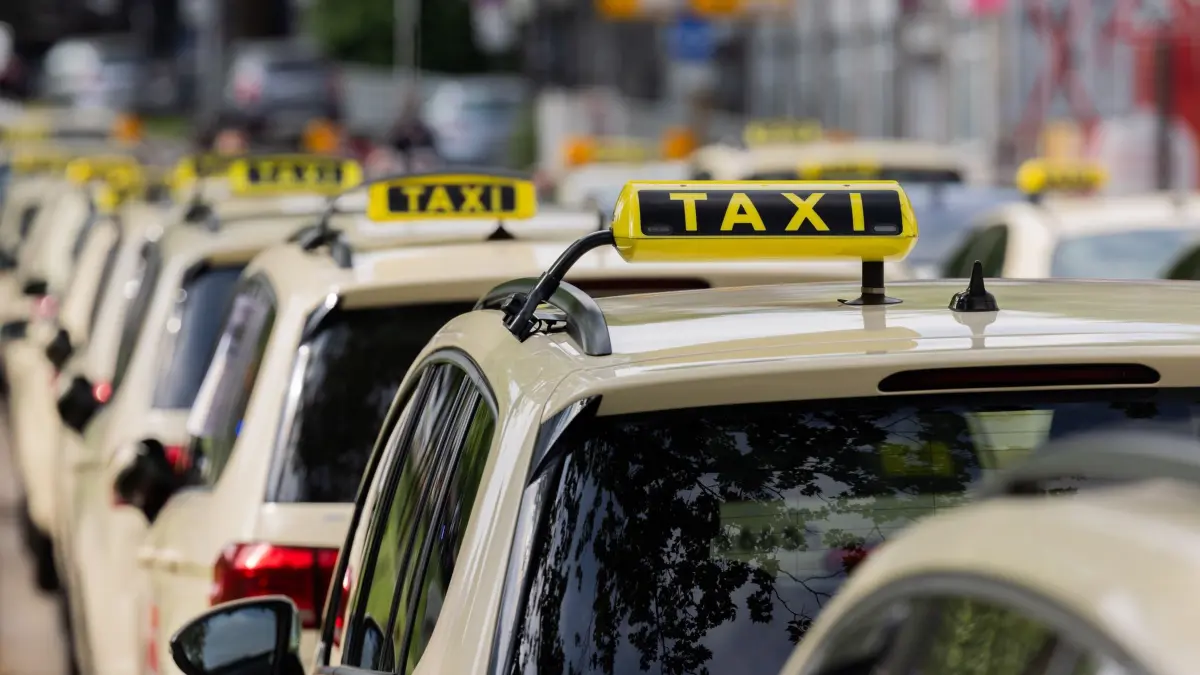 Taxifahrer: ARCHIV - 07.05.2025, Nordrhein-Westfalen, Essen: Taxifahrer blockieren aus Protest gegen Mietwagenanbieter wie Uber die Hauptverkehrsstraße Schützenbahn vor dem Rathaus. Mit strikten Preisvorgaben für Uber und andere Anbieter von Mietwagen-Fahrten will die Stadt Essen die Taxi-Branche vor einem ruinösen Wettbewerb schützen. Der Rat hat beschlossen, dass private Anbieter ihre Fahrten in Essen ab 1. Januar nicht mehr sehr viel günstiger anbieten dürfen als nach Taxi-Tarif. (zu dpa: «Stadt Essen verbietet sehr günstige Preise bei Uber-Fahrten») Foto: Rolf Vennenbernd/dpa +++ dpa-Bildfunk +++