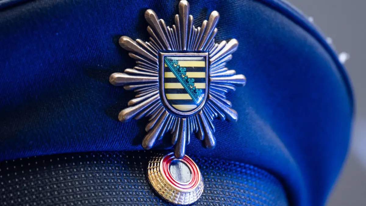 Polizei in Sachsen: ARCHIV - 18.01.2024, Sachsen, Dresden: Das Wappen der sächsischen Polizei ist an der Mütze eines Polizisten angebracht. (zu dpa: «Regierung einigt sich auf Entwurf für neues Polizeigesetz») Foto: Robert Michael/dpa +++ dpa-Bildfunk +++