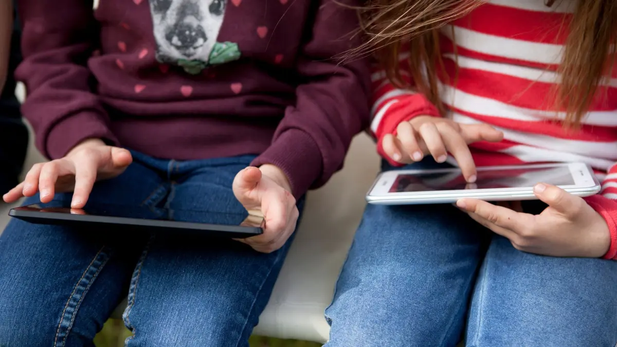 Zwei Kinder spielen etwas auf ihren Tablets: ILLUSTRATION - Mit einem Wisch ist alles da: Kinder verstehen meist intuitiv, wie die Dinge funktionieren - für die Mechanismen dahinter aber müssen sie sensibilisiert werden. (zu dpa: «Guck mal da! Was Eltern und Kinder über Medien lernen können») Foto: Silvia Marks/dpa Themendienst/dpa-tmn - Honorarfrei nur für Bezieher des dpa-Themendienstes +++ dpa-Themendienst +++