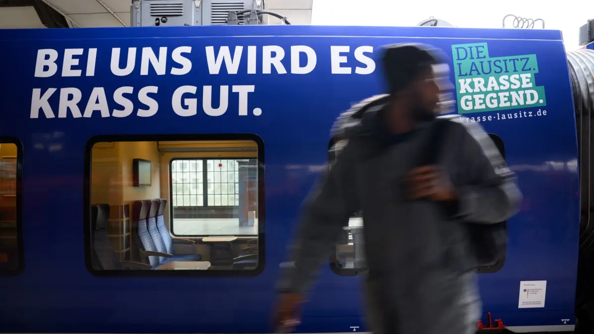Strukturwandel-Express-Zug „Krasse Lausitz“: 06.10.2025, Berlin: Der „Strukturwandel-Express-Zug“ „Krasse Lausitz“ steht bei einem Pressetermin zur feierlichen Einweihung des Zuges der Regionalexpress-Linie RE7 (Berlin - Dessau - Senftenberg) im Design der regionalen Imagekampagne „Die Lausitz. Krasse Gegend.“ im Bahnhof Friedrichstraße. Die als Braunkohlerevier bekannte Lausitz steckt angesichts des Kohleausstiegs bis 2038 in einem wirtschaftlichen Umbruchprozess. Der neu beschriftete Zug soll die enge Verbindung zwischen der Lausitz und der Hauptstadt sichtbar machen. Foto: Bernd von Jutrczenka/dpa +++ dpa-Bildfunk +++