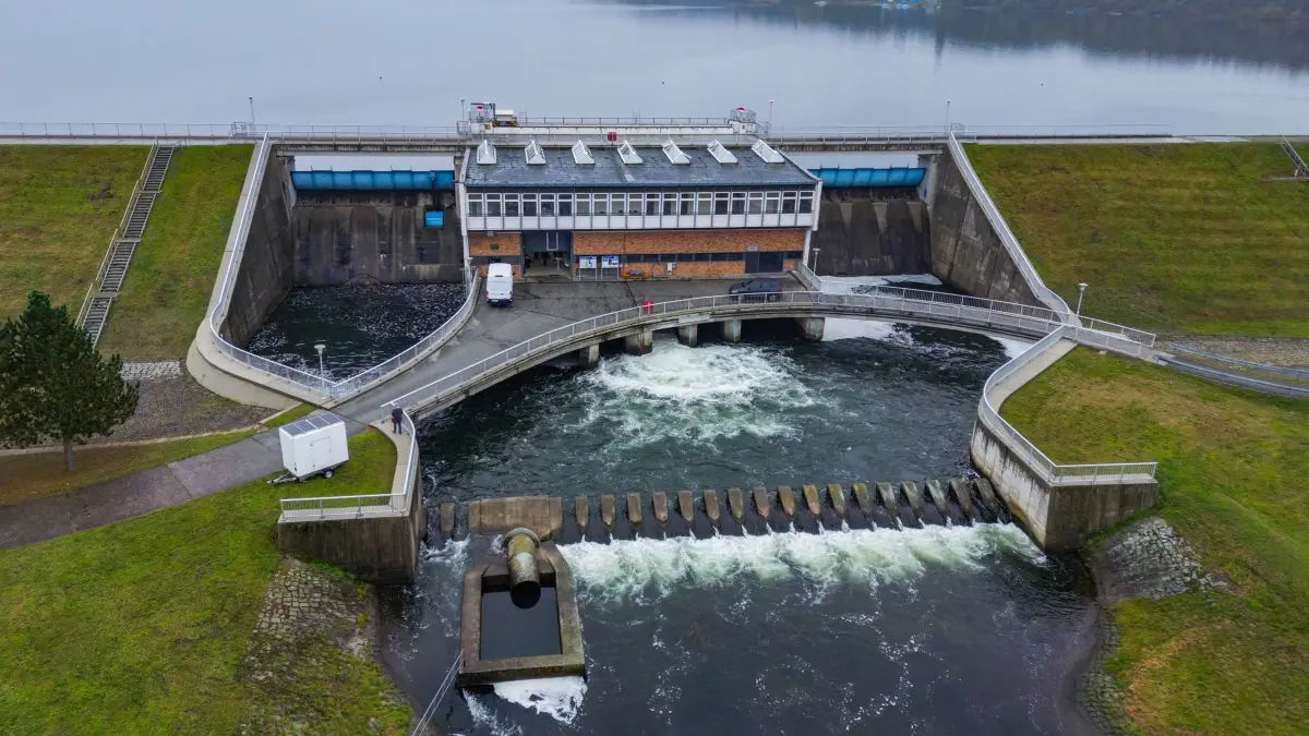 60 Jahre Talsperre Spremberg: 08.10.2025, Brandenburg, Neuhausen/Spree: Die Talsperre Spremberg mit dem Ablassbauwerk (Luftaufnahme mit einer Drohne). Mit einem Festakt und Technik-Touren wurde am selben Tag das 60-jährige Bestehen der Talsperre Spremberg gefeiert. Die größte wasserwirtschaftliche Anlage des Landes wurde 1965 in Betrieb genommen und spielt laut brandenburgischem Umweltministerium bis heute eine zentrale Rolle für den Wasserhaushalt der Lausitz und der Spree. Foto: Patrick Pleul/dpa +++ dpa-Bildfunk +++