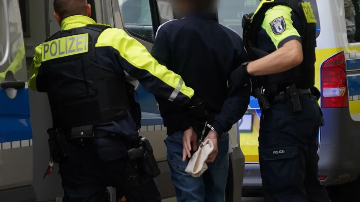 Festnahme wegen Menschenraub-Verdachts in Berliner Hotel: 10.10.2025, Berlin: Polizisten führen einen Jugendlichen zu einem Polizeiauto. Wegen des Verdachts des erpresserischen Menschenraubes hat die Berliner Polizei einen Jugendlichen und einen erwachsenen Mann festgenommen. Foto: Pierce Adler/dpa - ACHTUNG: Person wurde aus rechtlichen Gründen gepixelt +++ dpa-Bildfunk +++
